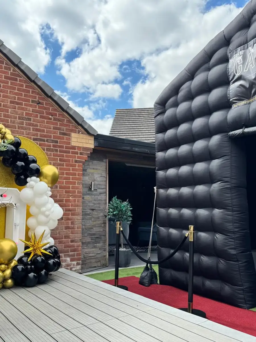 Gold and white balloon arch on decking beside the black club