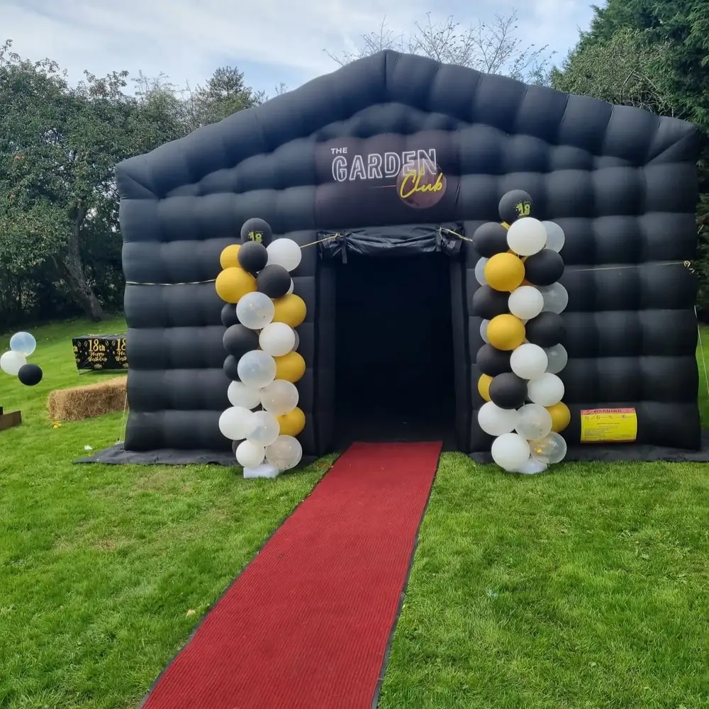 Black and gold balloon columns either side of the club entrance with a red carpet