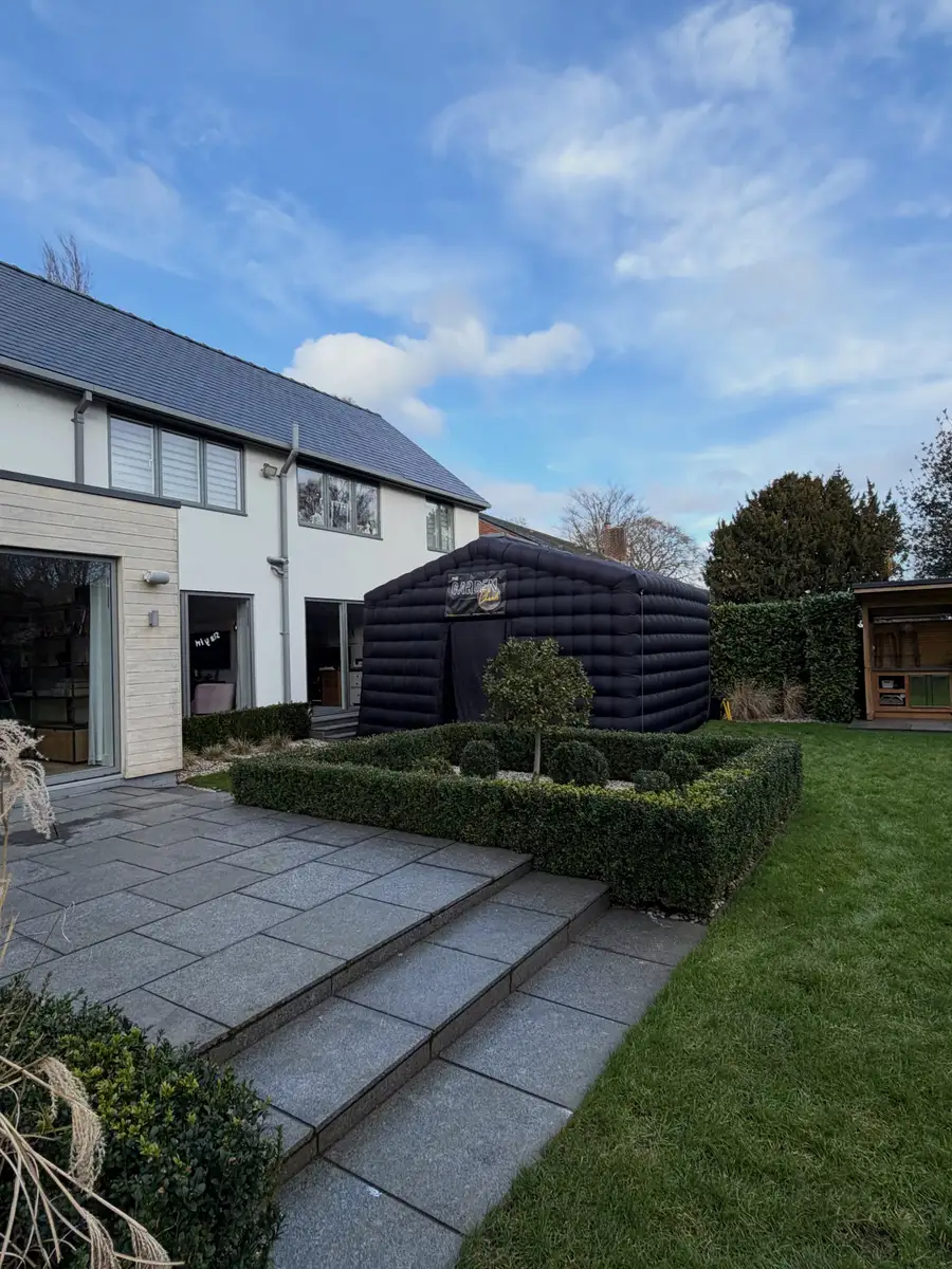 The club on a lawn behind a modern house and landscaped garden